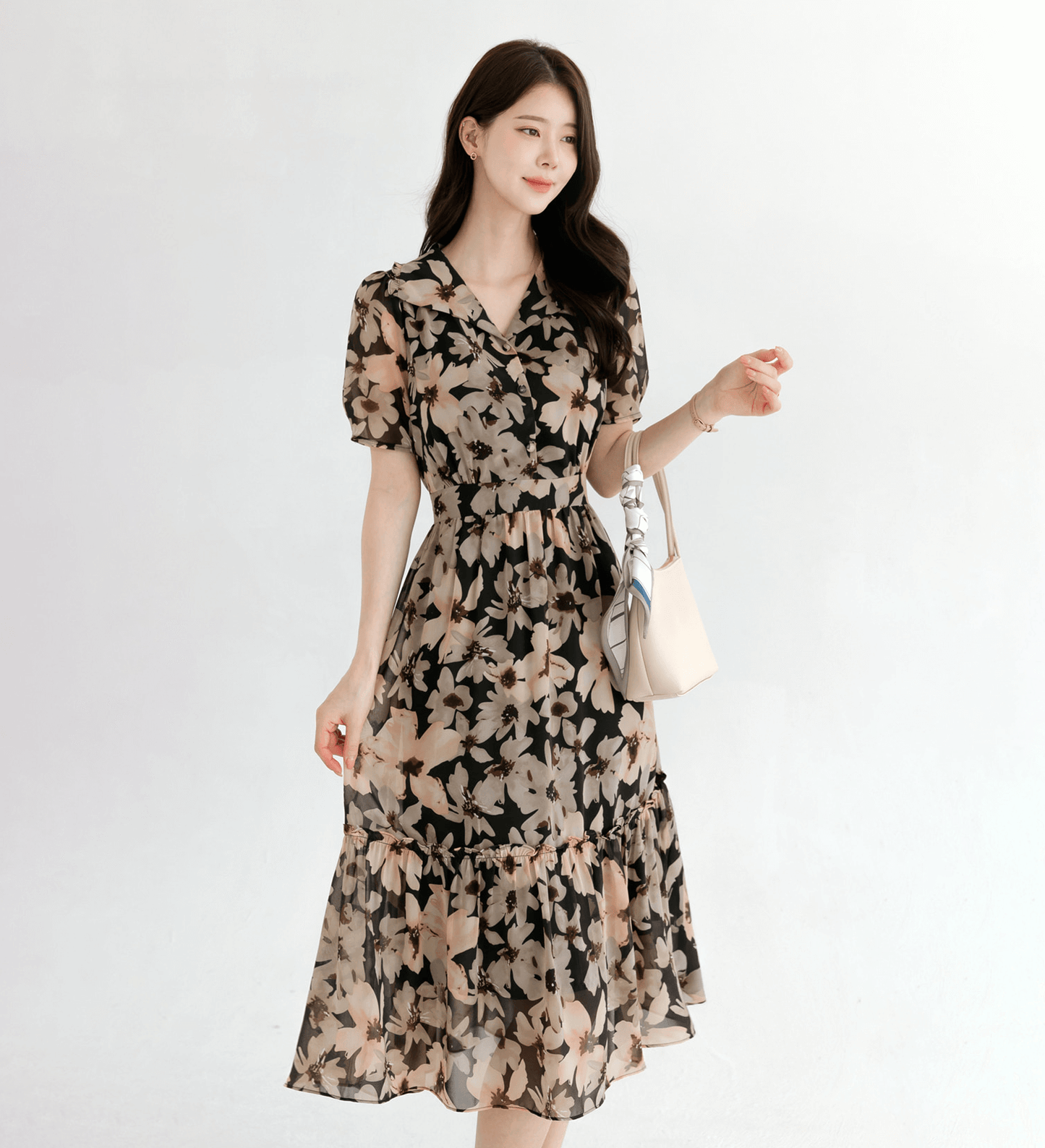 Woman wearing a floral chiffon dress with a wide flat collar, puff short sleeves, and a gently cinched waist, showcasing feminine style.