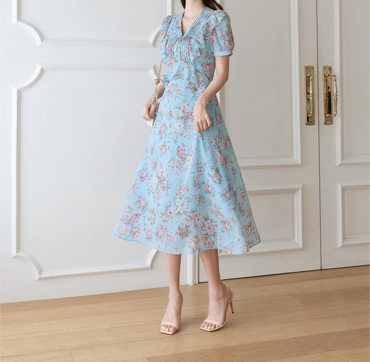 Floral chiffon dress with pintuck bodice and peplum detail in light sky blue, featuring a V-neckline and puffed sleeves.