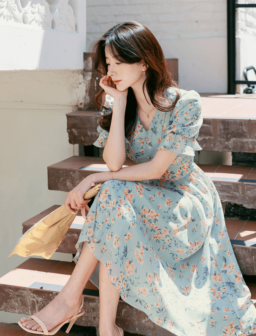 Woman wearing V-Neck Puff Sleeve Floral Chiffon Dress in Breezy Blue on stairs, showcasing spring fashion.