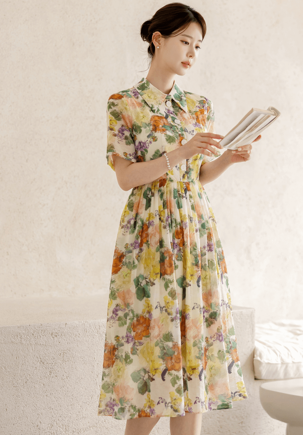 Woman wearing a romantic floral dress with pintuck detail and collar neckline, featuring a soft flare silhouette and subtle floral print.
