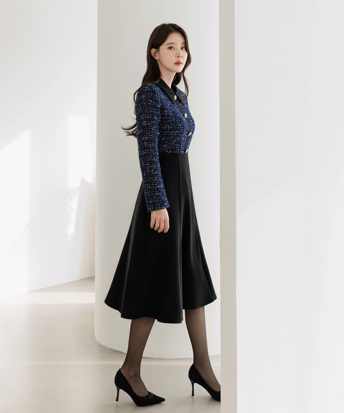 Two-tone tweed and black flare dress with gold buttons, featuring a navy tweed top and elegant black skirt.