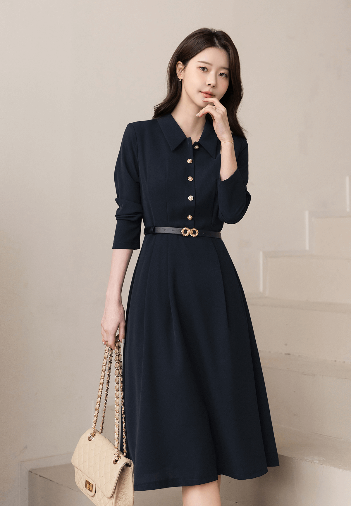 Elegant navy flare dress with long sleeves and belted waist, featuring a structured collar and pleats, perfect for polished occasions.
