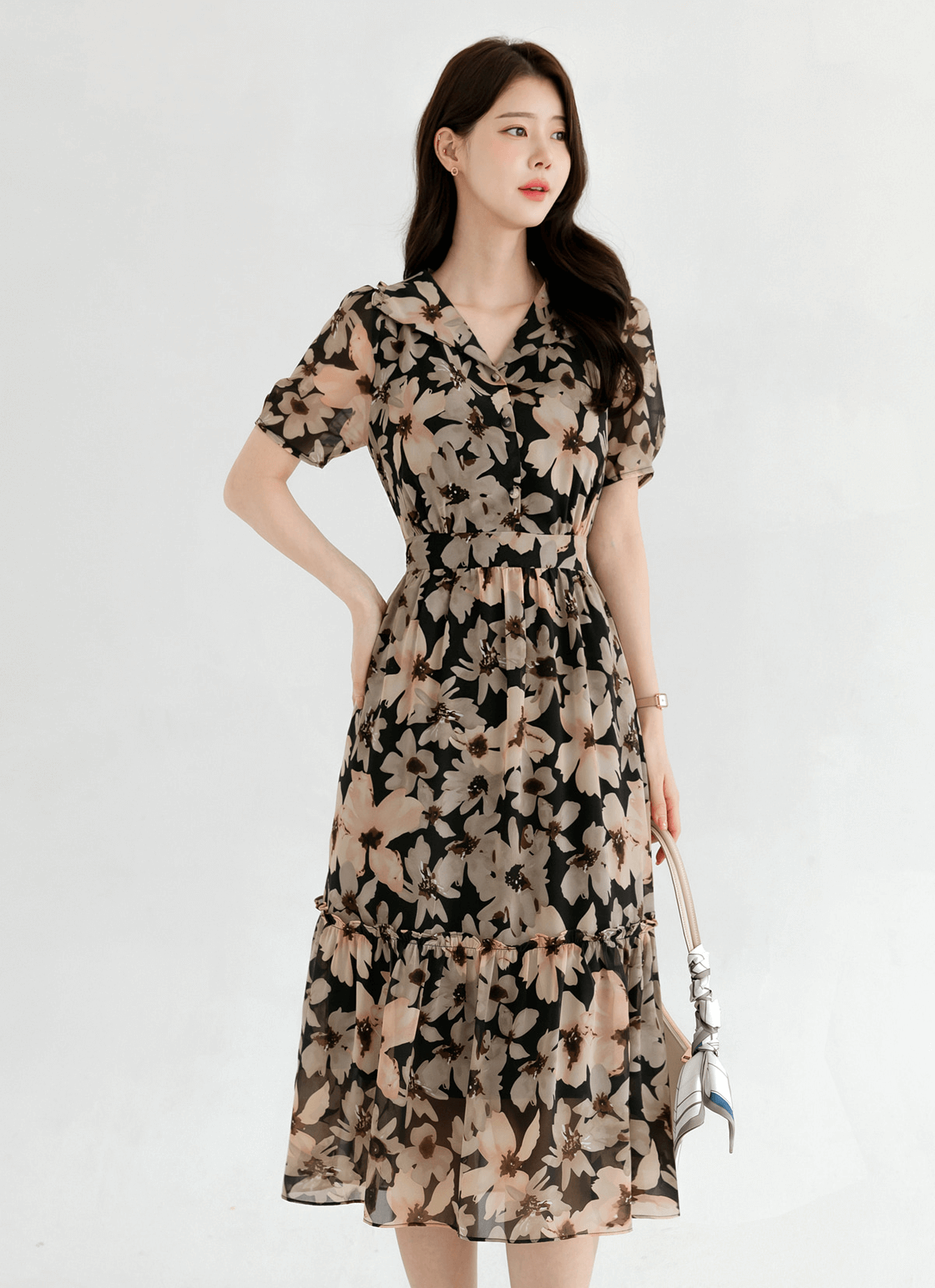Woman wearing floral chiffon dress with wide collar and puff short sleeves, showcasing an elegant and airy design.