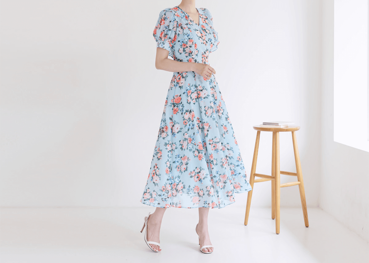Blue floral chiffon dress with V-neckline and puff sleeves, highlighted by high waist and flowing skirt, perfect for spring fashion.
