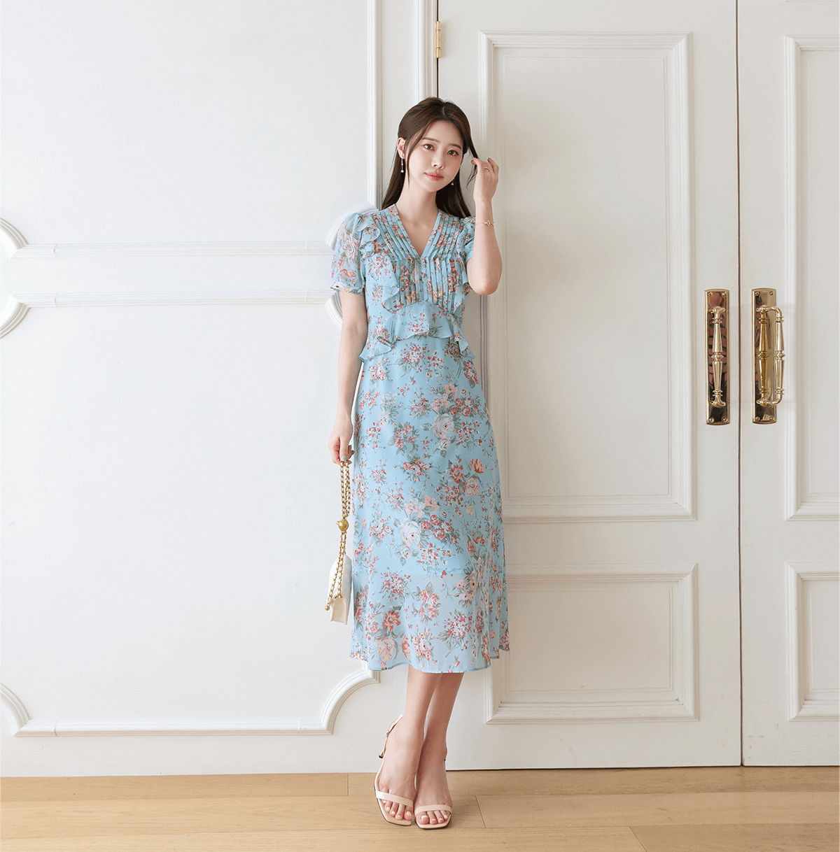 Light blue floral chiffon dress with pintuck bodice and peplum detail, featuring V-neckline and puffed sleeves, perfect for elegant occasions.