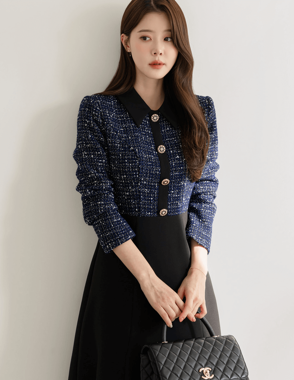 Two-tone tweed and black flare dress with gold button detail, featuring navy tweed top and smooth black skirt, elegant and sophisticated.