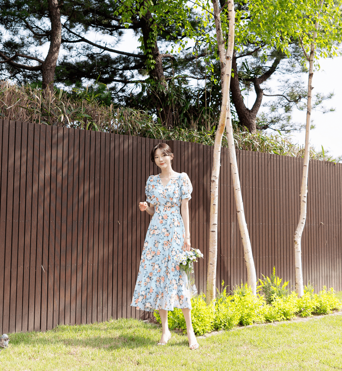 Romantic floral chiffon dress with short puff sleeves and V-neckline in a garden setting, perfect for spring.