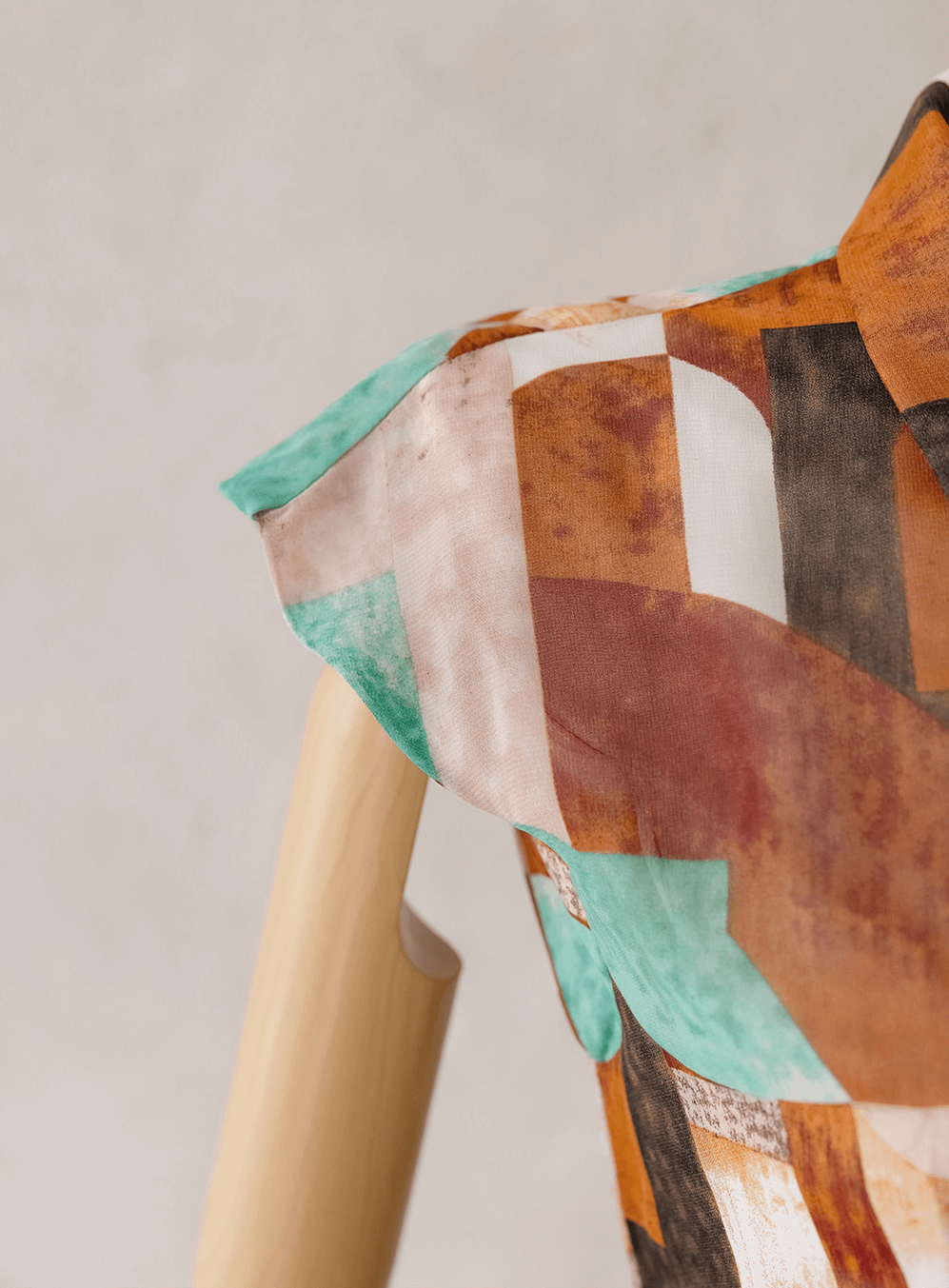 Close-up of shirt dress with soft cap sleeves, showing multicolor geometric print and elegant design.
