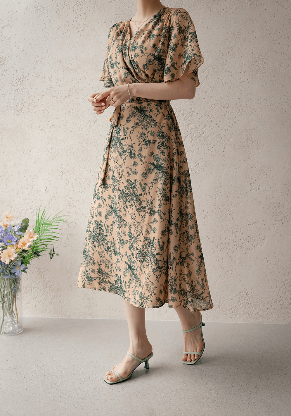 Goddess-inspired wrap dress with graceful wing sleeves, floral pattern, and adjustable ribbon tie for an elegant look.