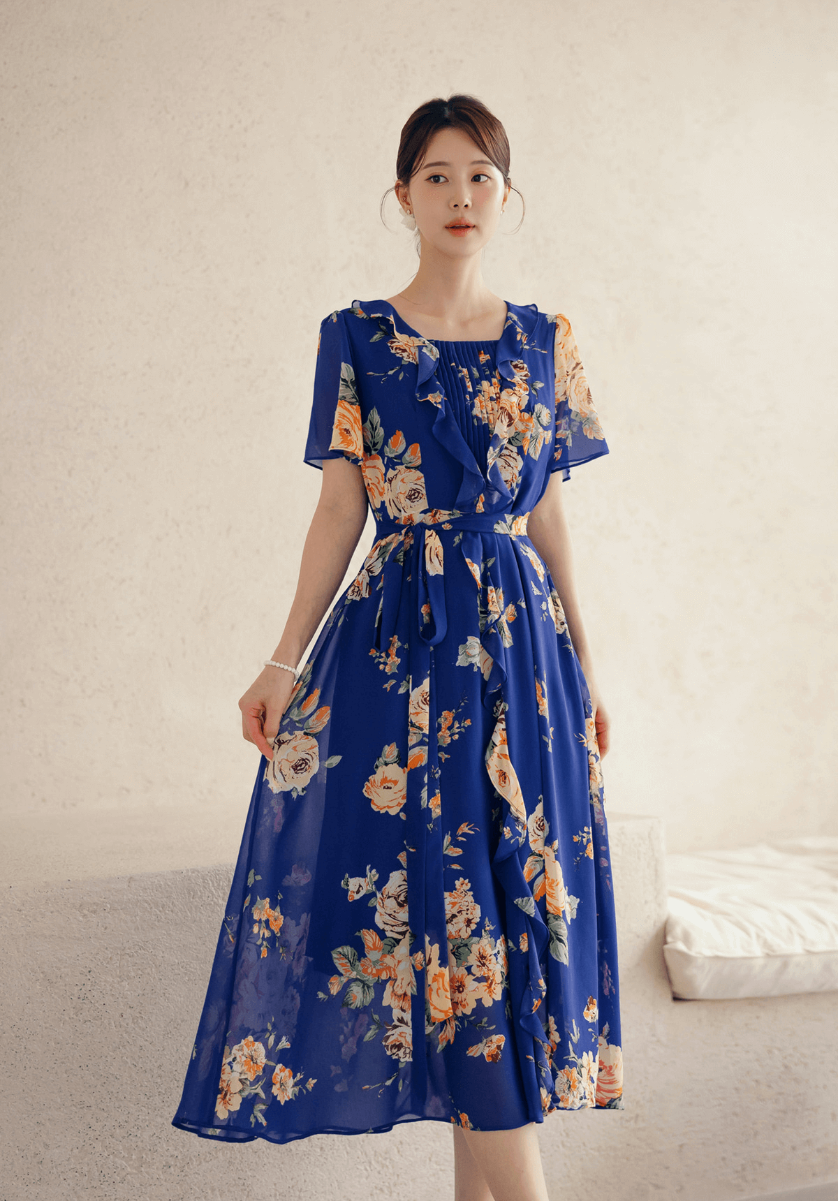 Woman wearing blue floral chiffon dress with square neckline and sheer wing sleeves, showcasing ethereal style and elegance.