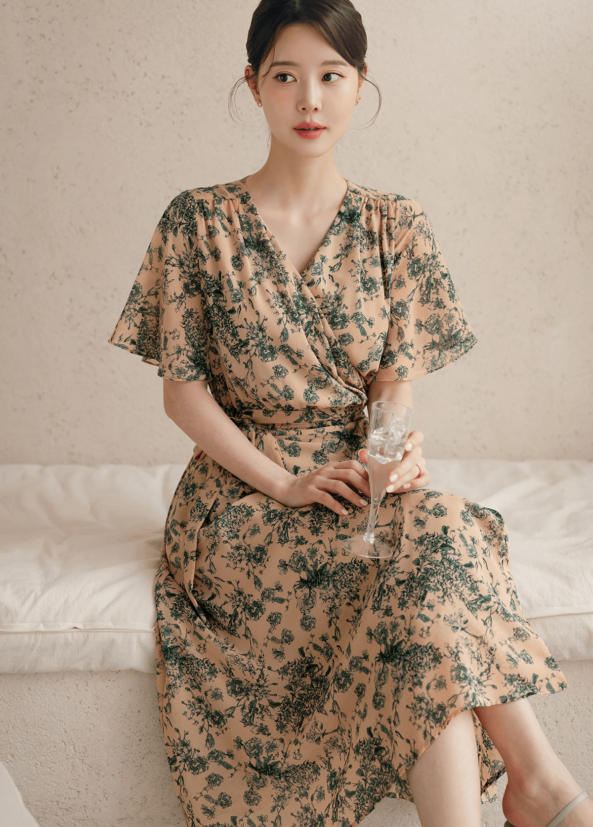 Goddess-inspired wrap dress with graceful wing sleeves, elegant drape and a flattering wrap neckline, modeled with refined style.