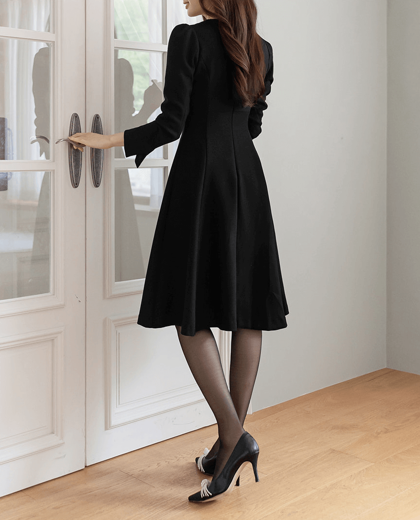 Vestido negro voluminoso con vuelo y drapeado