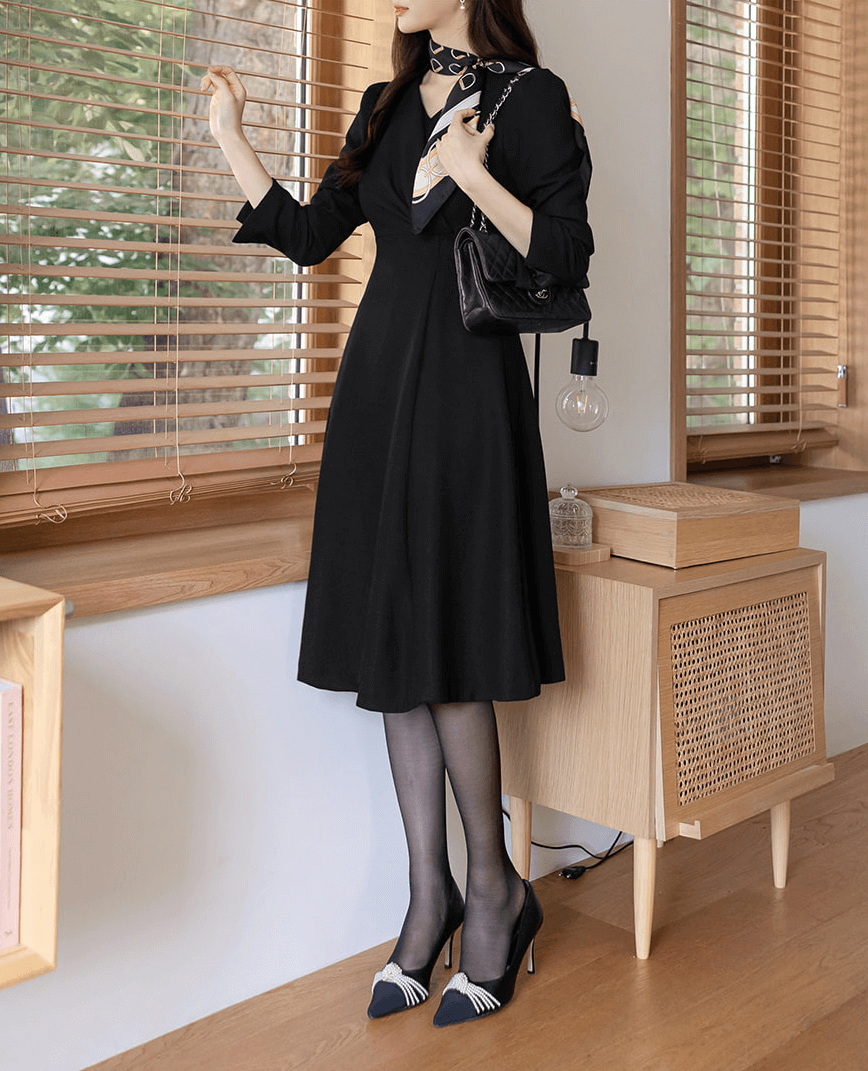 Vestido negro voluminoso con vuelo y drapeado