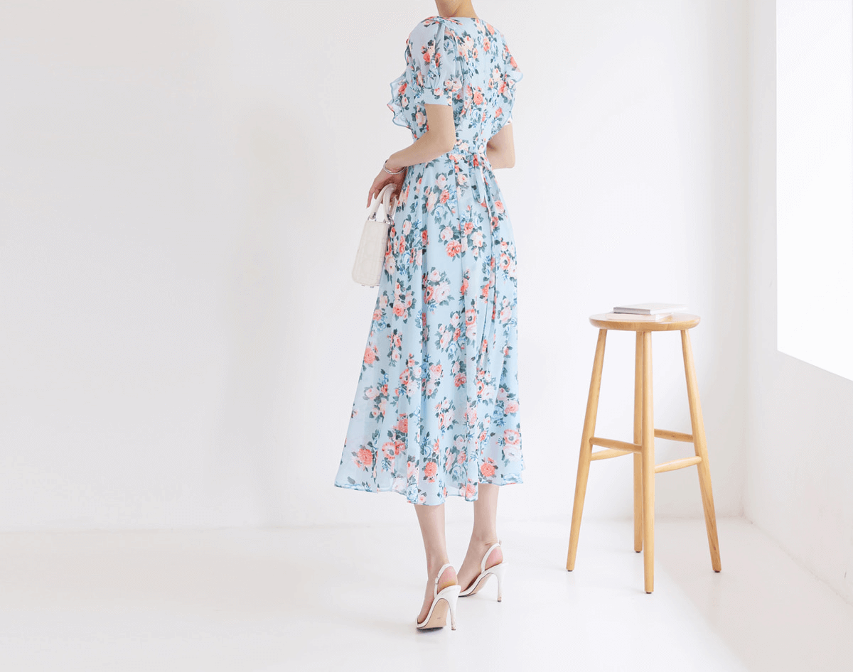 Back view of woman wearing blue floral chiffon dress with puff sleeves and V-neckline