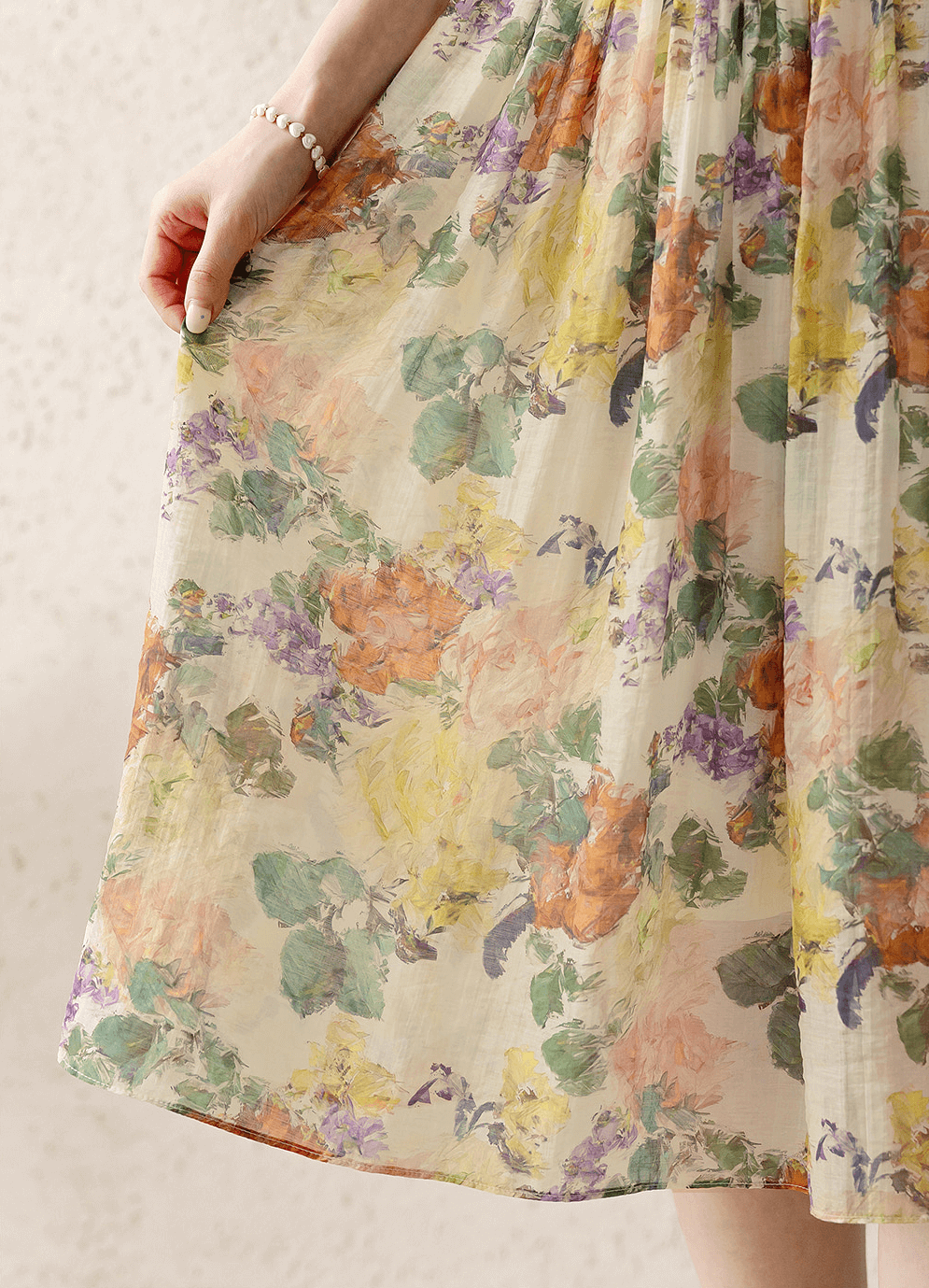 Close-up of romantic floral dress with pintuck detail and soft flare silhouette.