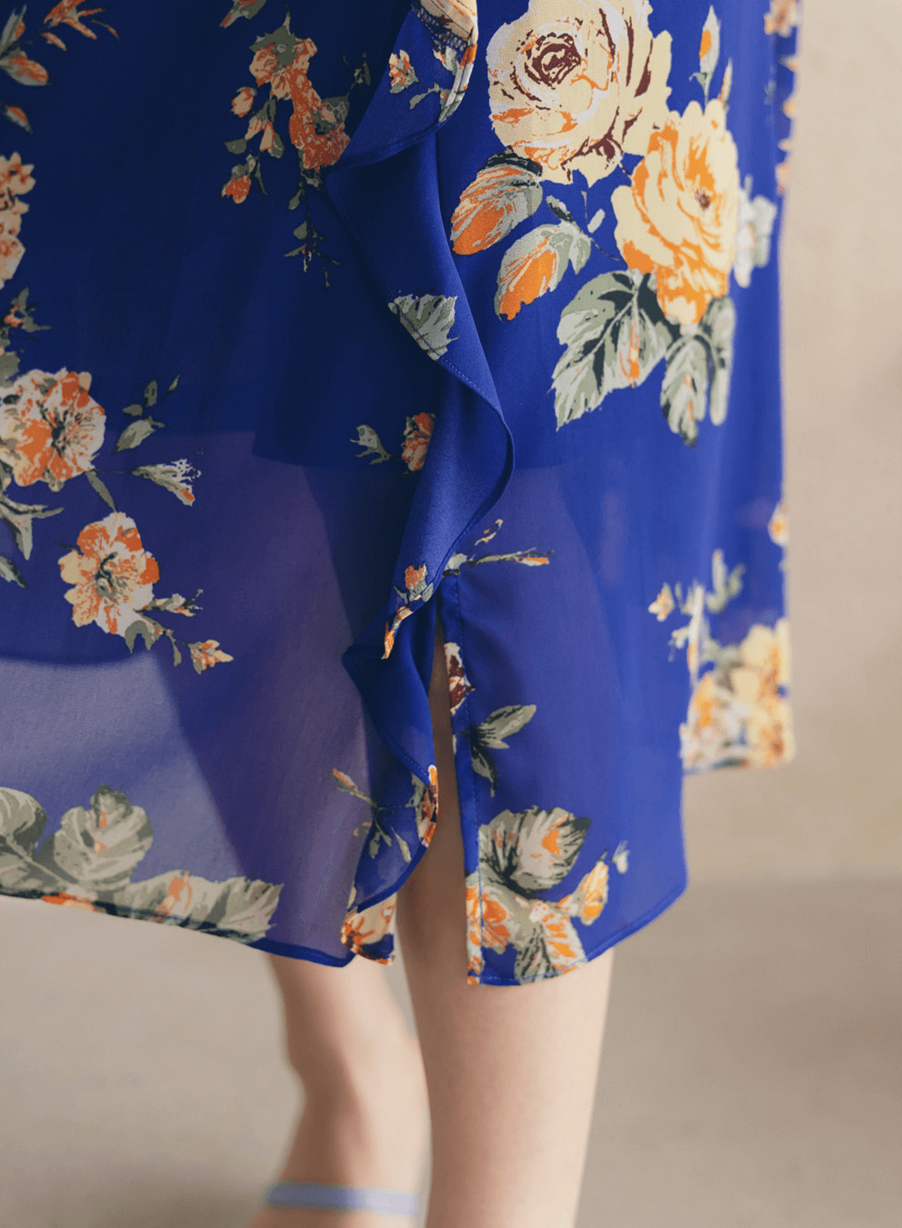 Close-up of a blue floral chiffon dress with sheer fabric and delicate patterns, showing a flowing, lightweight design.