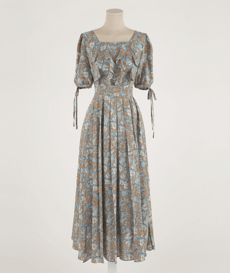 Elegant pleated dress with square neckline, slit sleeves, and ribbon ties, featuring a flowy A-line silhouette and delicate floral pattern.