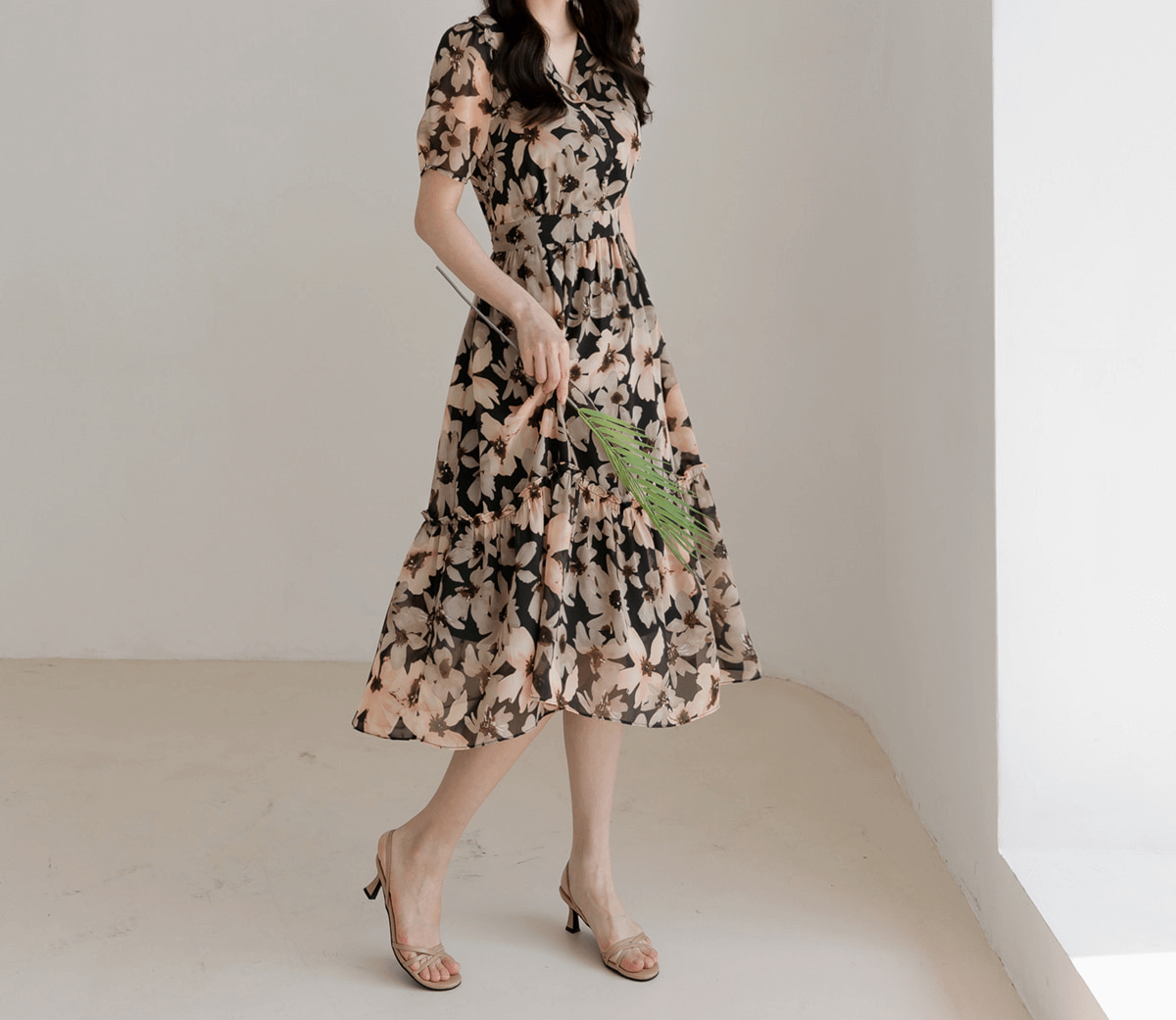 Woman wearing floral chiffon dress with wide collar and puff sleeves, showcasing flowy silhouette and feminine style.