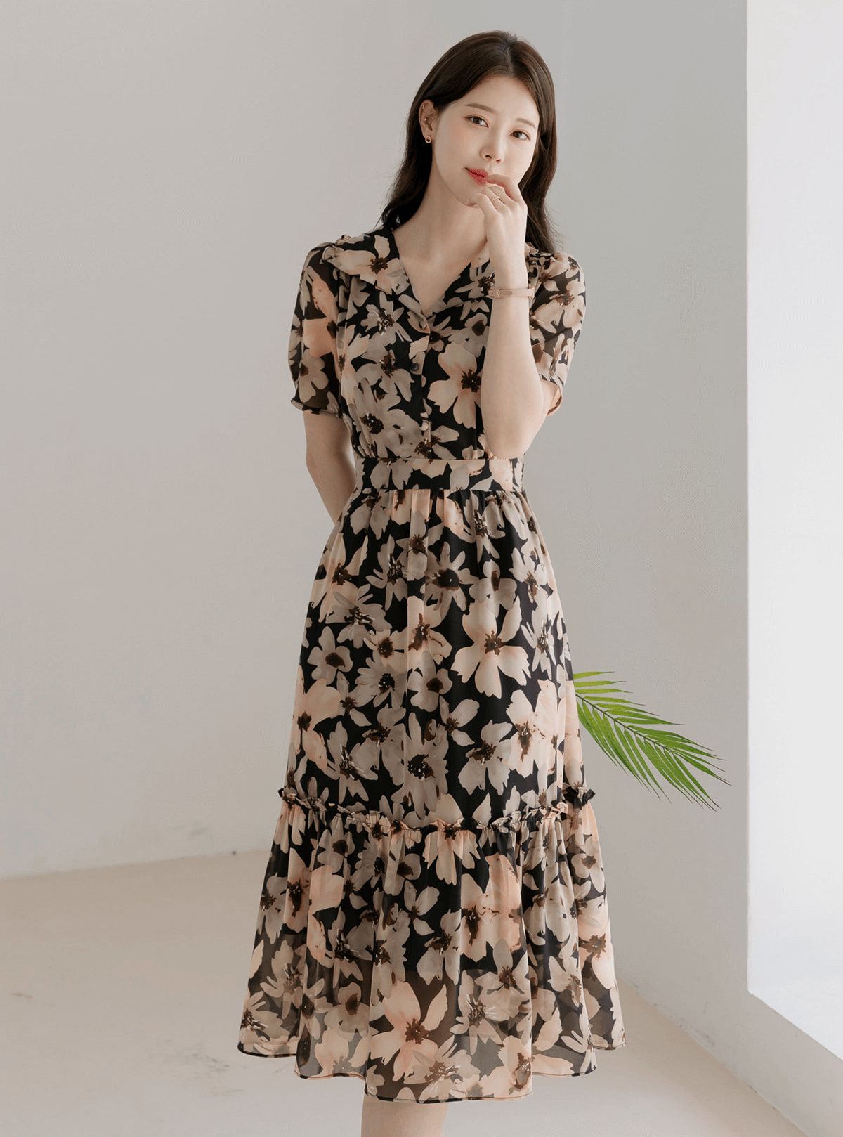 Woman wearing a floral chiffon dress with wide flat collar and puff short sleeves, showcasing feminine and airy style.