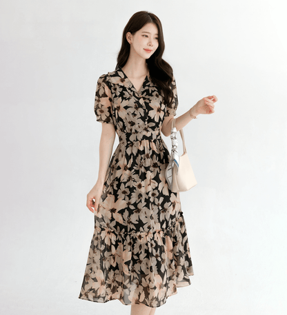 Woman wearing a floral chiffon dress with a wide flat collar, puff short sleeves, and a gently cinched waist, showcasing feminine style.