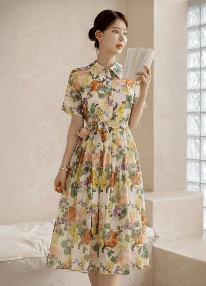 Woman wearing a romantic floral dress with pintuck detail and collar neckline, embodying elegance and grace.