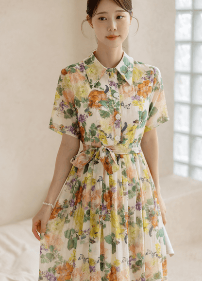 Romantic floral dress with pintuck detail and collar neckline, featuring a colorful print and soft flare silhouette.