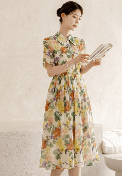Woman wearing a romantic floral dress with pintuck detail and collar neckline, featuring a soft flare silhouette and subtle floral print.