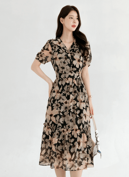 Woman wearing floral chiffon dress with wide collar and puff short sleeves, showcasing an elegant and airy design.