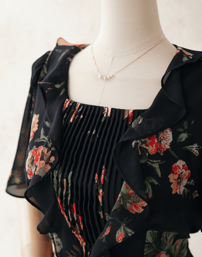 Floral chiffon dress with sheer wing sleeves, square neckline, and pleated bodice on a mannequin.