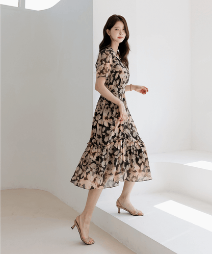 Woman wearing floral chiffon dress with wide flat collar and puff short sleeves, side view, walking gracefully in bright room.