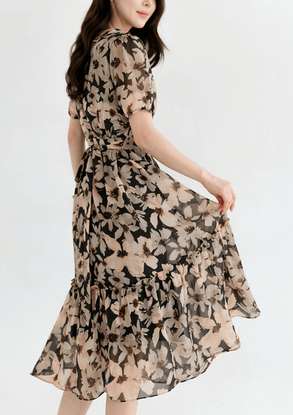 Woman wearing a floral chiffon dress with wide flat collar and puff short sleeves, showcasing an airy, feminine silhouette.