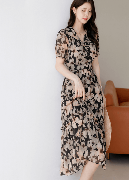 Woman wearing a floral chiffon dress with wide collar and puff sleeves, standing elegantly.