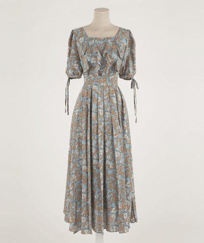 Elegant pleated dress with square neckline, slit sleeves, and ribbon ties, featuring a flowy A-line silhouette and delicate floral pattern.