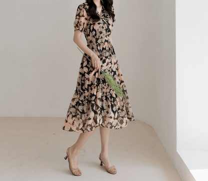 Woman wearing floral chiffon dress with wide collar and puff sleeves, showcasing flowy silhouette and feminine style.